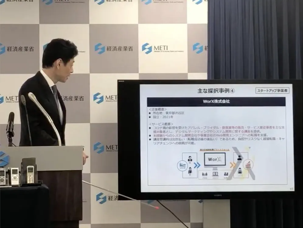 経済産業省の会見で採択事業の1つとしてWorX株式会社が紹介される様子
